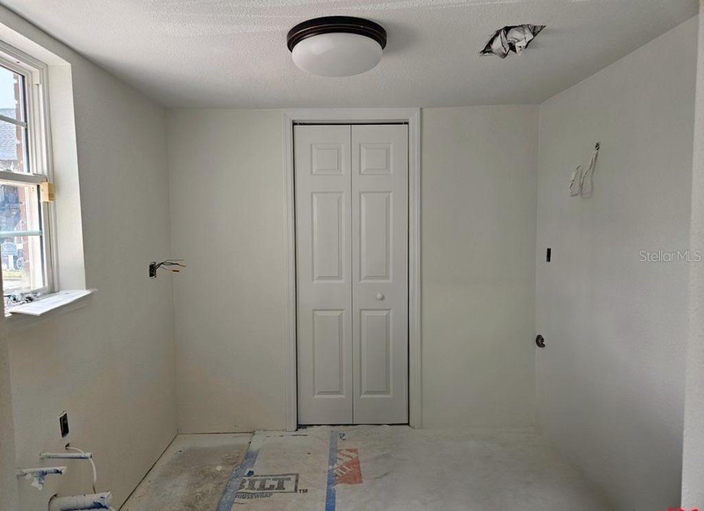 An unfinished room features white walls, a bi-fold closet door, and exposed electrical wiring — 200 COUNTRY CLUB DRIVE UNIT 1101, LARGO, FL