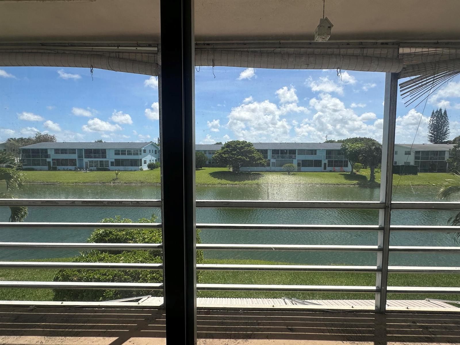 A view of a canal and apartment buildings from a screened-in balcony — 72 Northampton D, West Palm Beach FL 33417, WEST PALM BEACH, FL