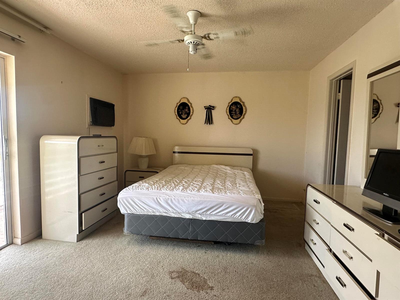 A bedroom features a bed, two white dressers, a ceiling fan, and beige carpeting — 72 Northampton D, West Palm Beach FL 33417, WEST PALM BEACH, FL