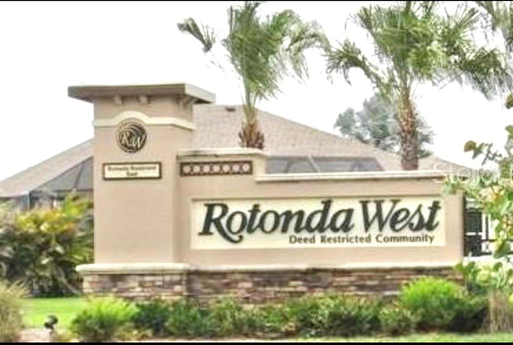 A beige stucco monument sign for the Rotonda West deed restricted community stands outdoors — 168 WHITE PINE DRIVE, ROTONDA WEST, FL