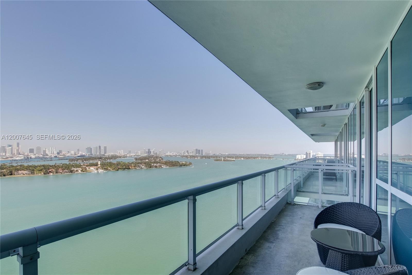 A high-rise balcony overlooks a bay with a city skyline in the distance — 540 West Ave # 2112, Miami Beach FL 33139, MIAMI BEACH, FL