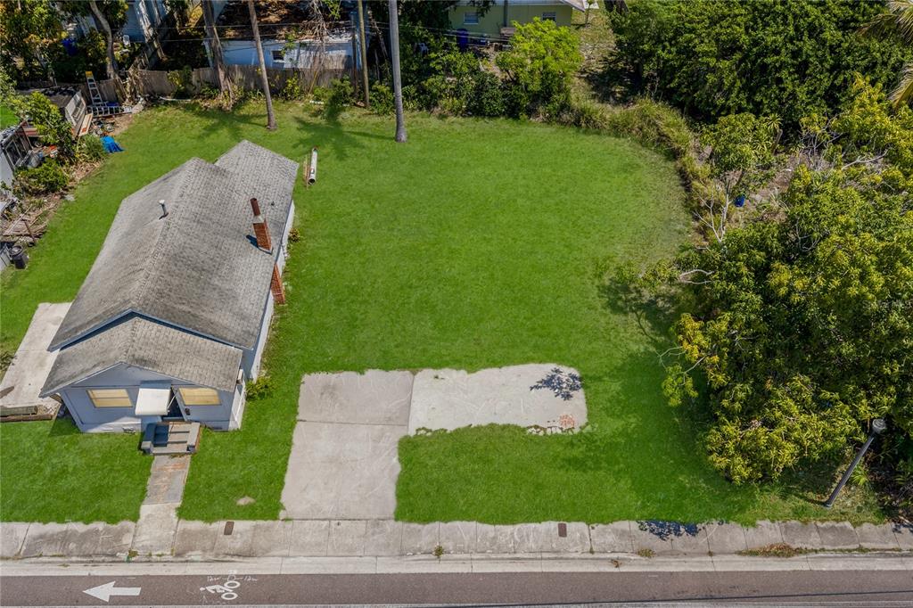 An aerial view shows a small house with a large, grassy yard and concrete driveway — 15TH AVENUE S, ST PETERSBURG, FL