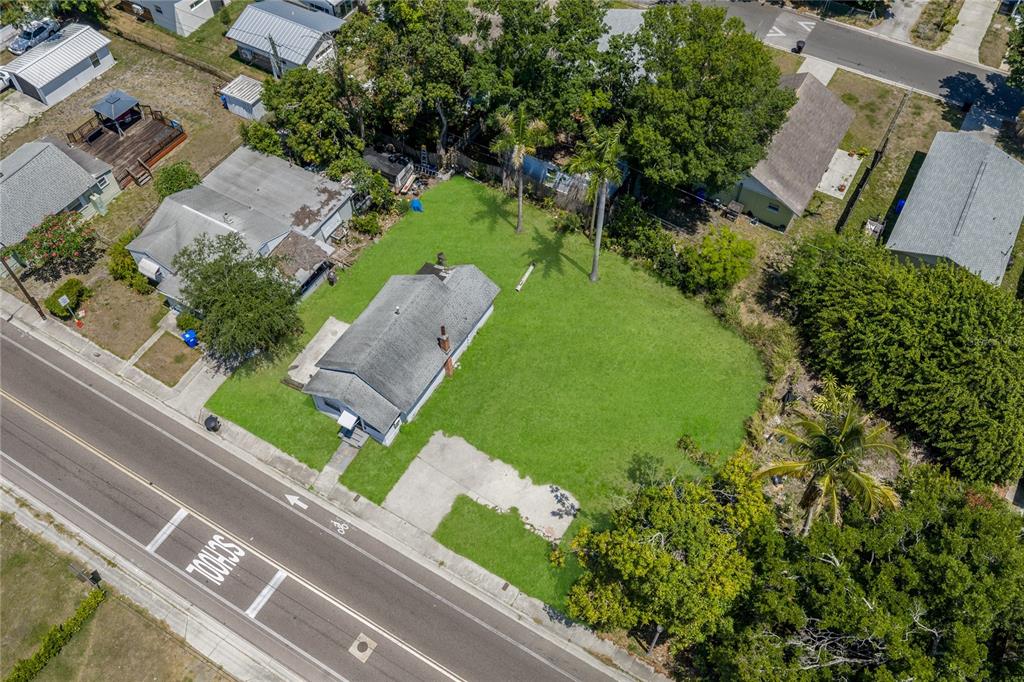 An aerial view shows a single-story house with a large grassy yard near a road — 15TH AVENUE S, ST PETERSBURG, FL