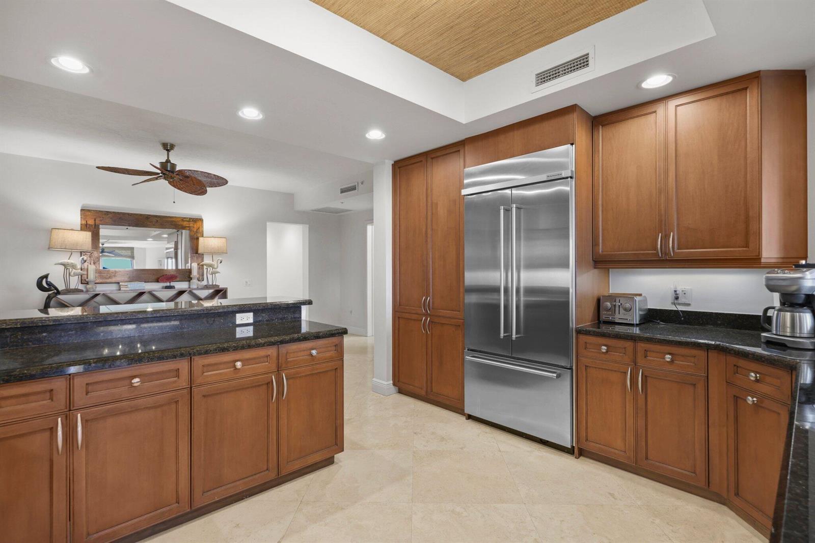A kitchen features wood cabinets, granite countertops, stainless steel appliances, and a tray ceiling — 500 S Us Highway 1 # 202, Jupiter FL 33477, JUPITER, FL