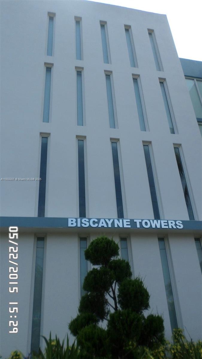 The exterior of the white Biscayne Towers building features multiple vertical windows and signage — 11750 NE 16th Ave # 102, Miami FL 33161, MIAMI, FL