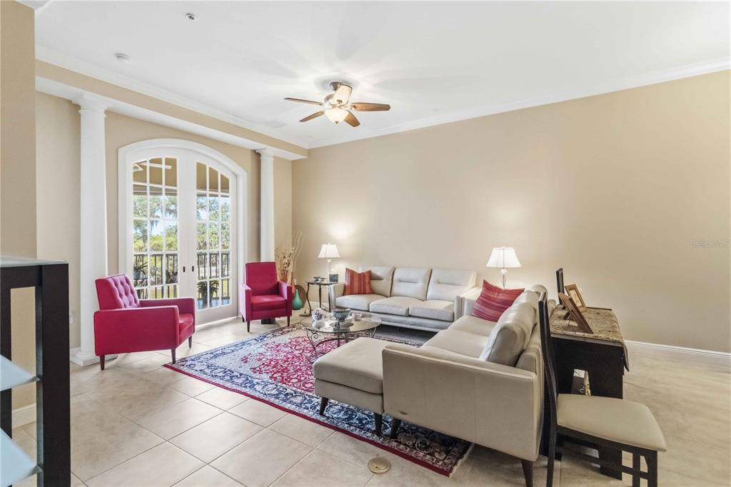 A living room features beige walls, tile floors, a ceiling fan, and two red armchairs — 5246 MANORWOOD DRIVE UNIT 4C, SARASOTA, FL