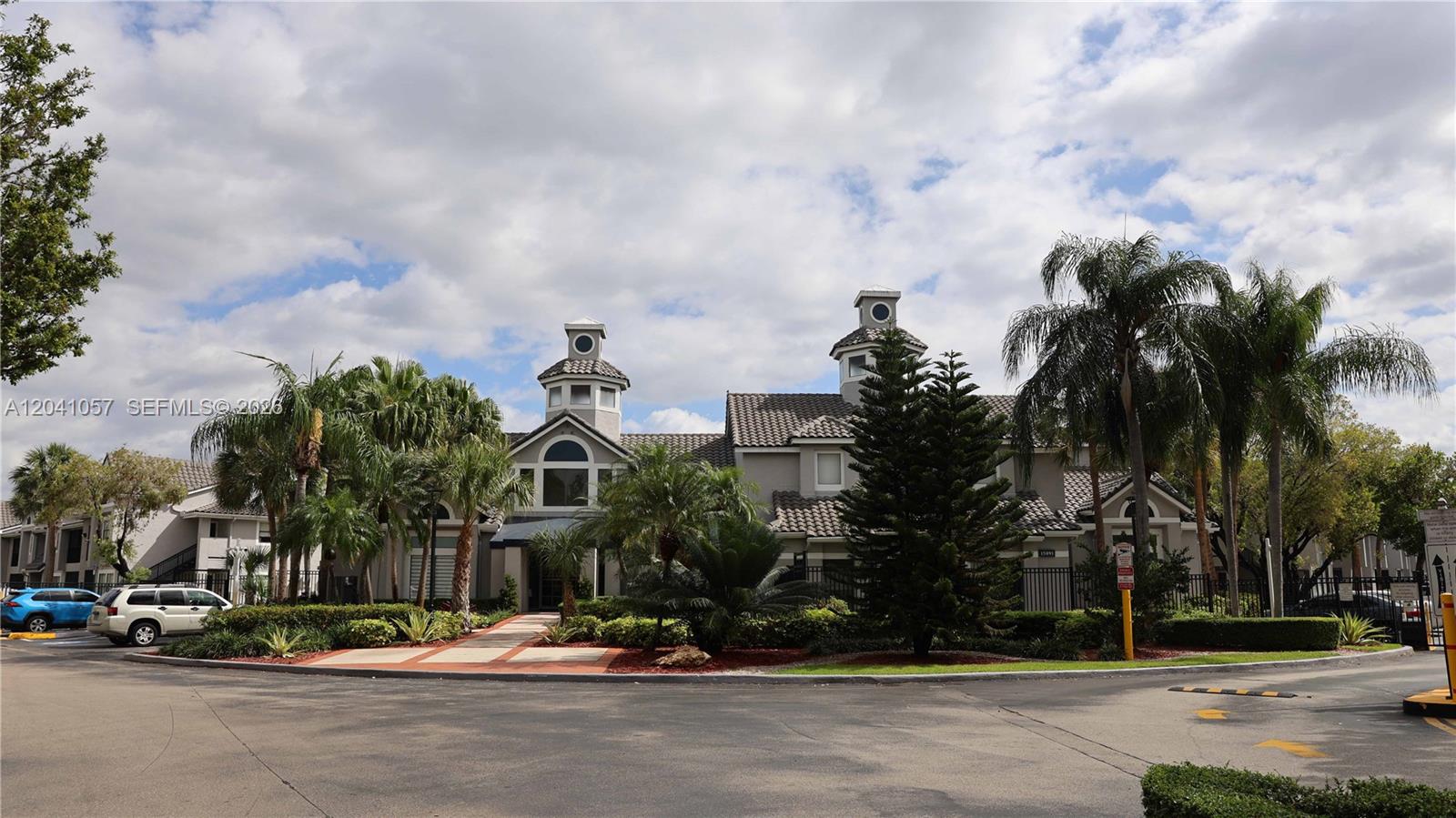 A two-story building with a tiled roof and two cupolas sits behind palm trees — 15077 SW 103rd Ter # 8110, Miami FL 33196, MIAMI, FL