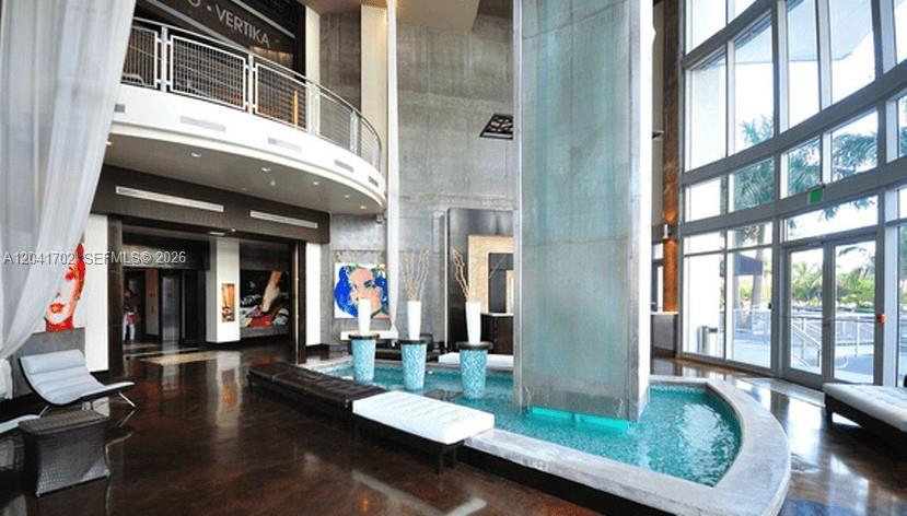 A modern lobby features a central water feature, high ceilings, and floor-to-ceiling windows — 690 SW 1st Ct # 3118, Miami FL 33130, MIAMI, FL