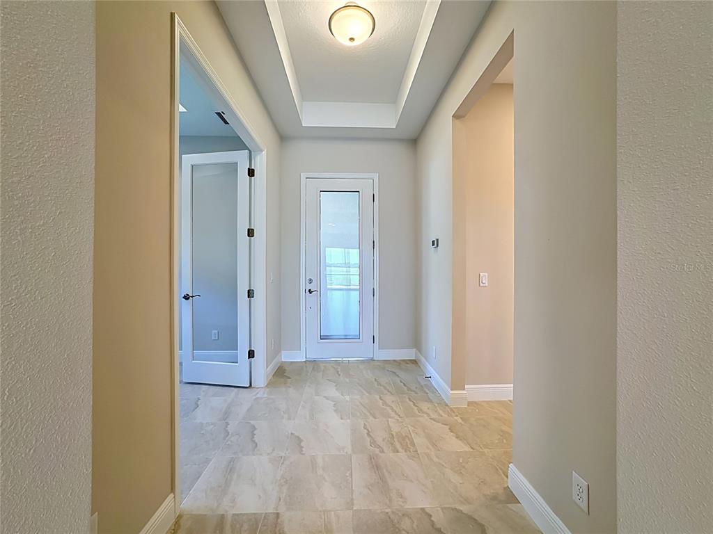 A tiled entryway features a tray ceiling, a glass-paneled door, and a French door entrance — 239 MONET TRAIL, BRADENTON, FL