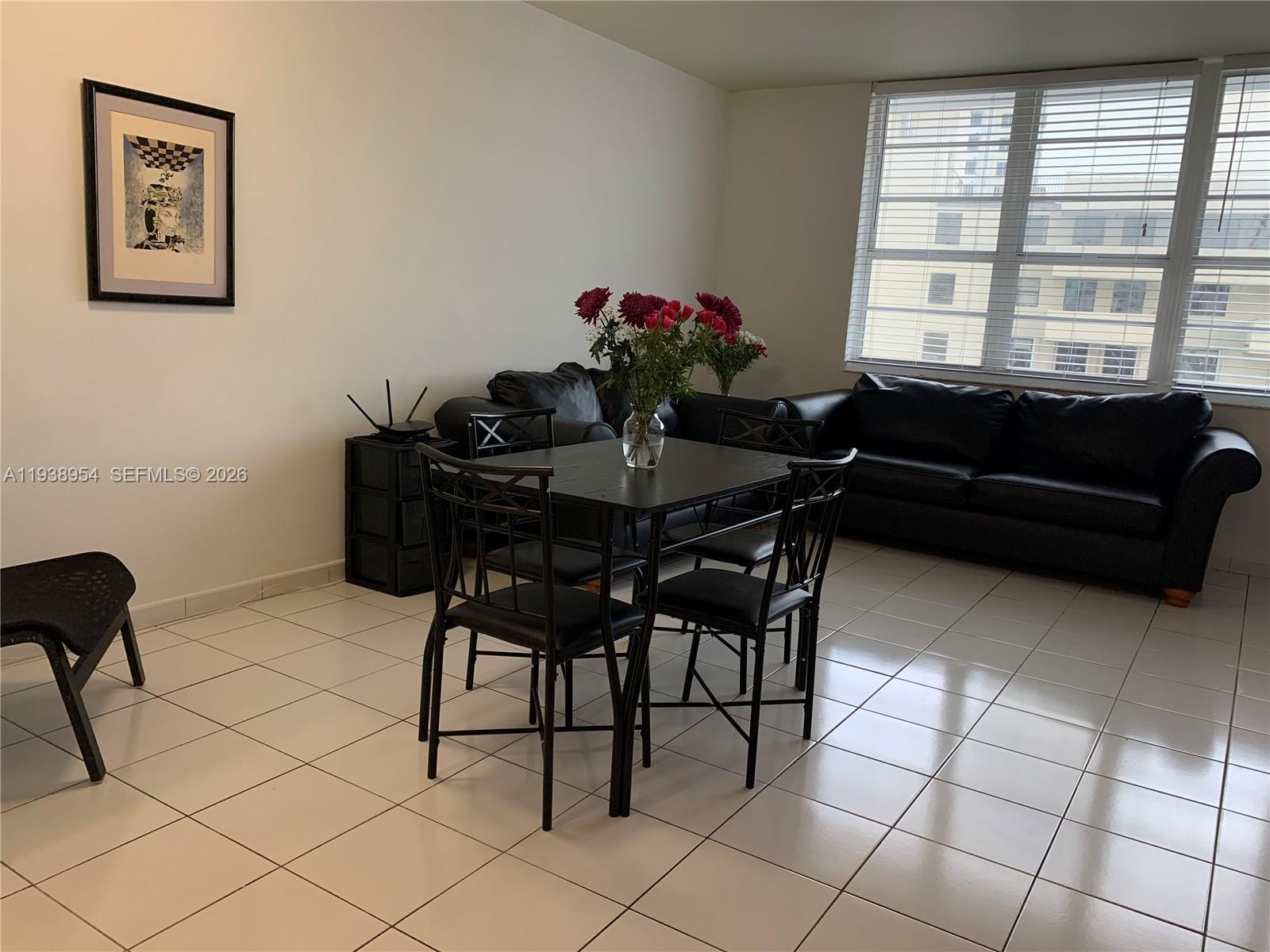 A dining area with a black table and chairs sits before a large window — 100 Lincoln Rd # 805, Miami Beach FL 33139, MIAMI BEACH, FL