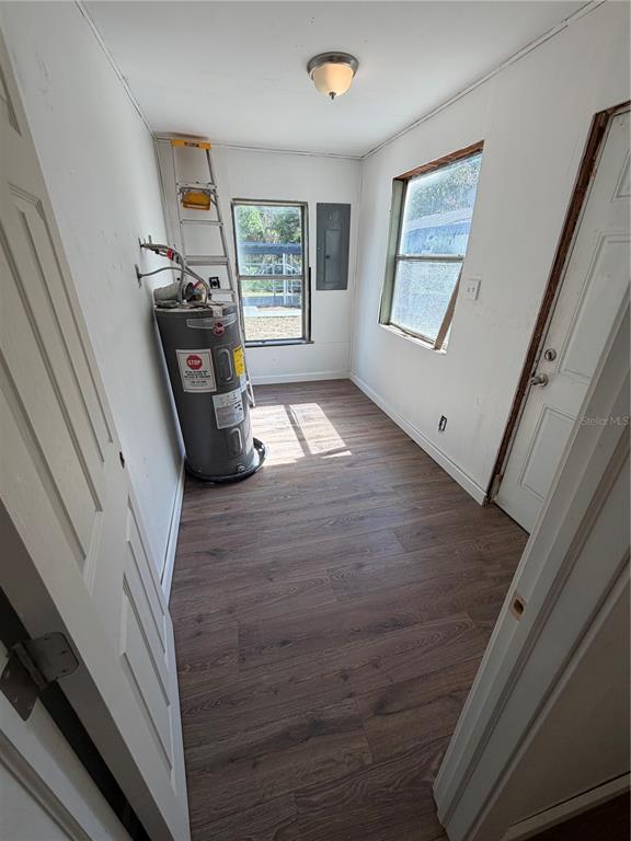 A kitchen with dark cabinets and white countertops opens into a living area with flooring — 911 N 21ST STREET, FORT PIERCE, FL