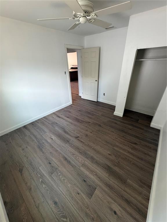 A utility room features wood-look flooring, a water heater, a ladder, and two windows — 911 N 21ST STREET, FORT PIERCE, FL