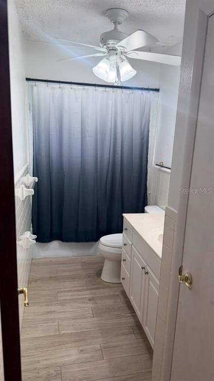 A bathroom features a white vanity, a toilet, and a blue ombre shower curtain — 6412 N WOODLYNNE AVENUE, TAMPA, FL