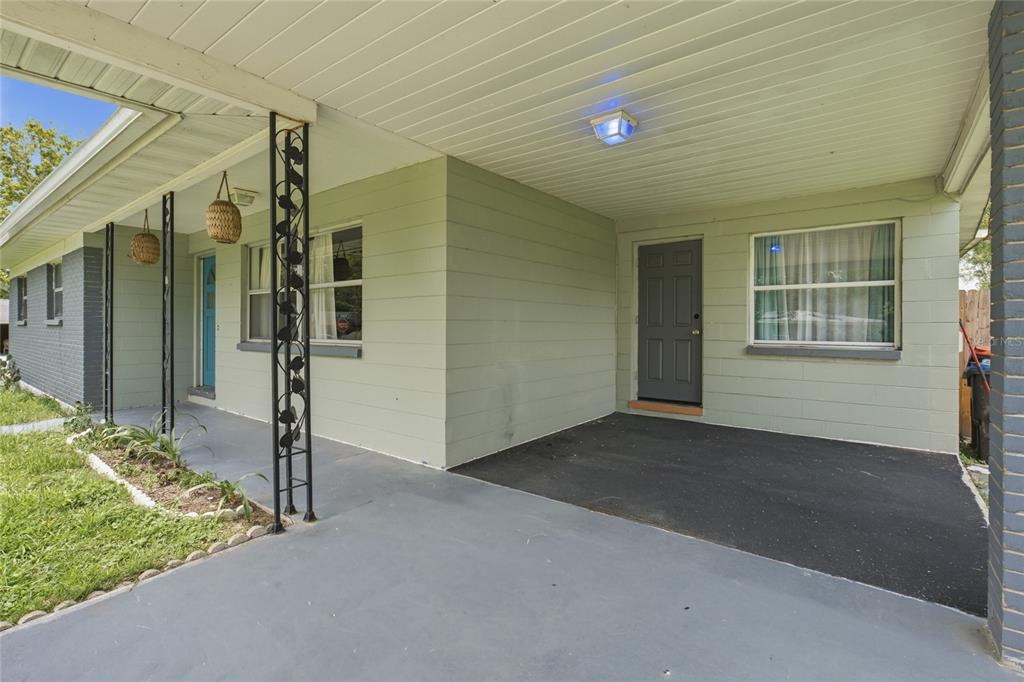 A covered concrete porch features decorative metal columns, light green siding, and two entry doors — 5307 SE 108TH STREET, BELLEVIEW, FL