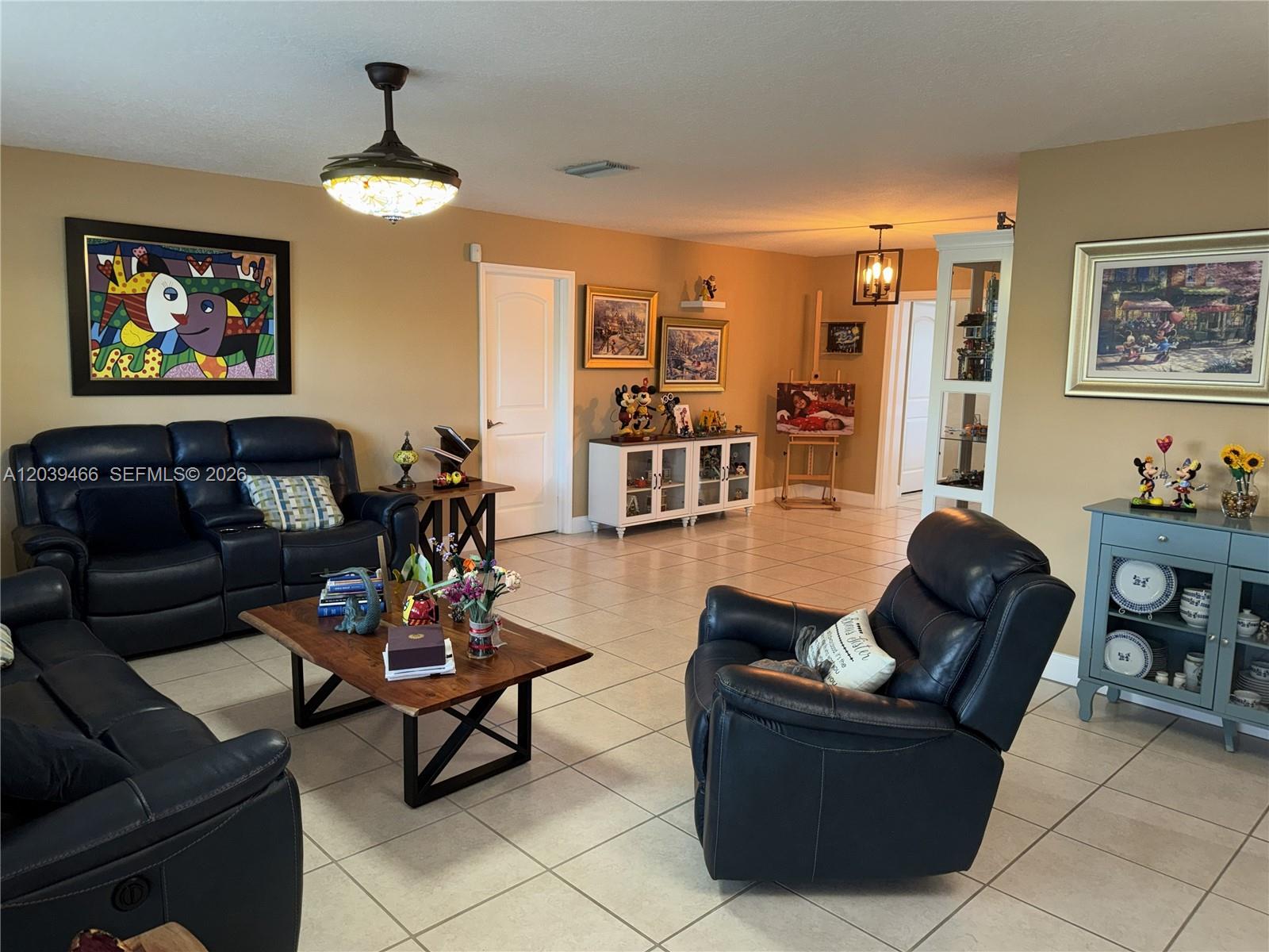 A living room features dark leather furniture, tile flooring, and several pieces of wall art — 4301 Adams St, Hollywood FL 33021, HOLLYWOOD, FL