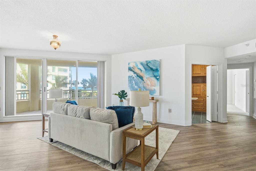 A living room with light wood floors, a sofa, and a balcony overlooking the ocean — 1170 SE GULF BOULEVARD UNIT 305, CLEARWATER BEACH, FL