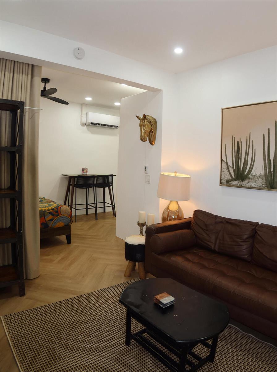 A living room with a brown leather sofa, coffee table, and an adjacent dining area — 3408 Spring Street # 3, Pompano Beach FL 33062, POMPANO BEACH, FL