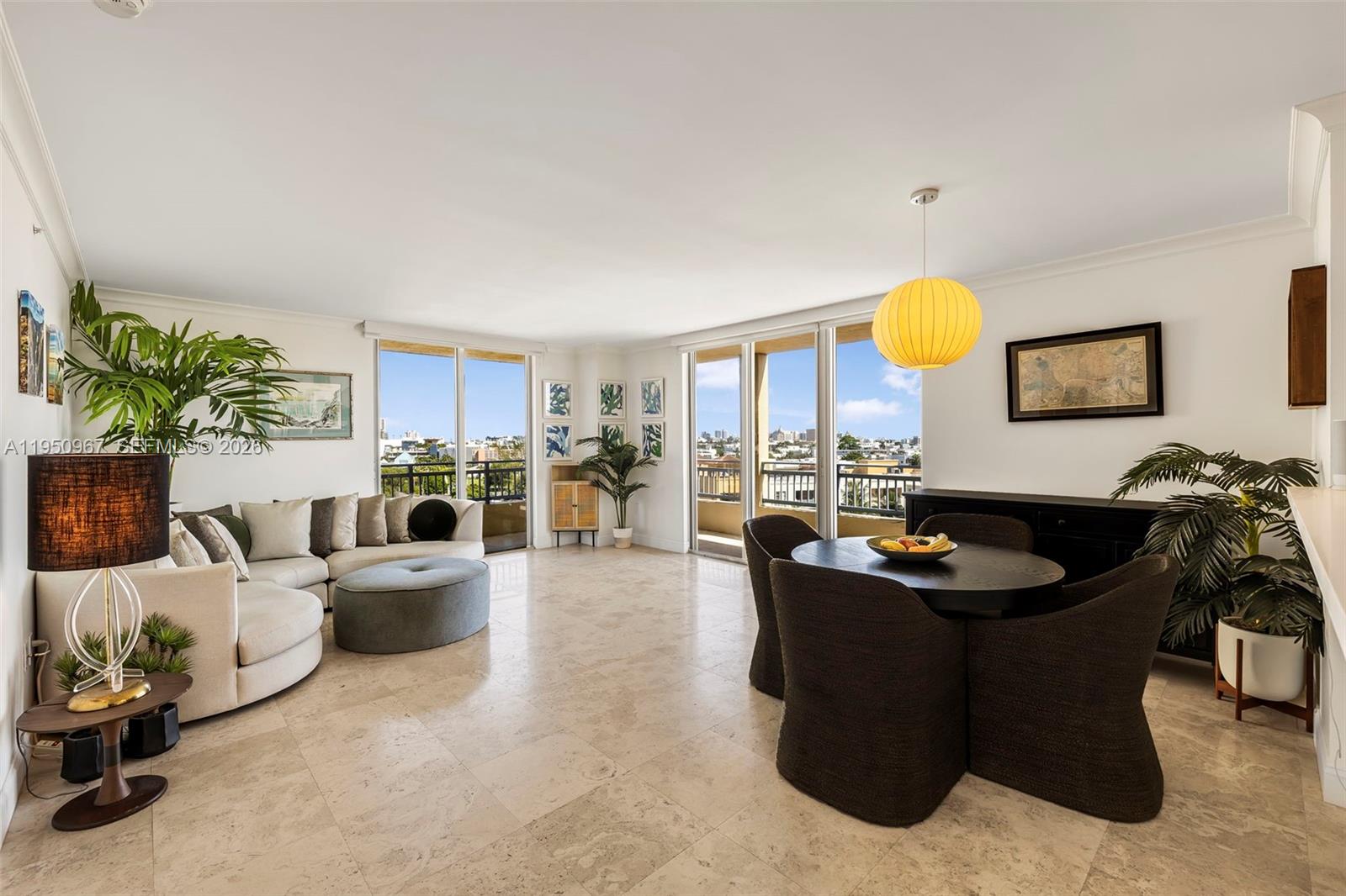 A bright living and dining area features tile floors, floor-to-ceiling windows, and a balcony view — 90 Alton Rd # 811, Miami Beach FL 33139, MIAMI BEACH, FL