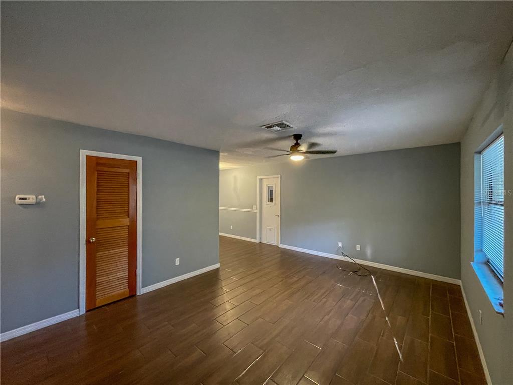 A living room with light gray walls, tile flooring, and an open-concept kitchen and dining area — 9875 W ORCHARD STREET, CRYSTAL RIVER, FL
