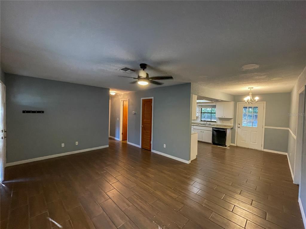 A bedroom with gray walls, wood-look tile flooring, a mirrored closet, and an attached bathroom — 9875 W ORCHARD STREET, CRYSTAL RIVER, FL