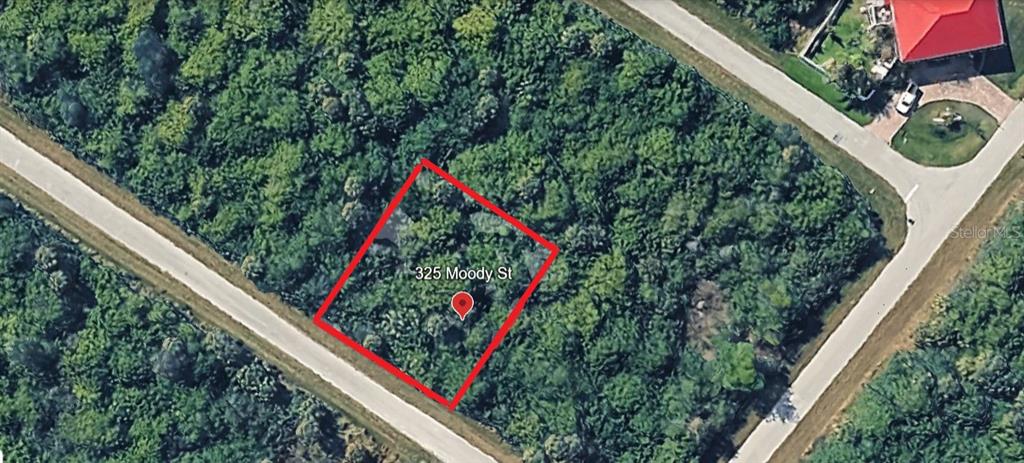 An aerial view shows a rectangular plot of land outlined in red amidst dense vegetation — 325 MOODY STREET, PORT CHARLOTTE, FL