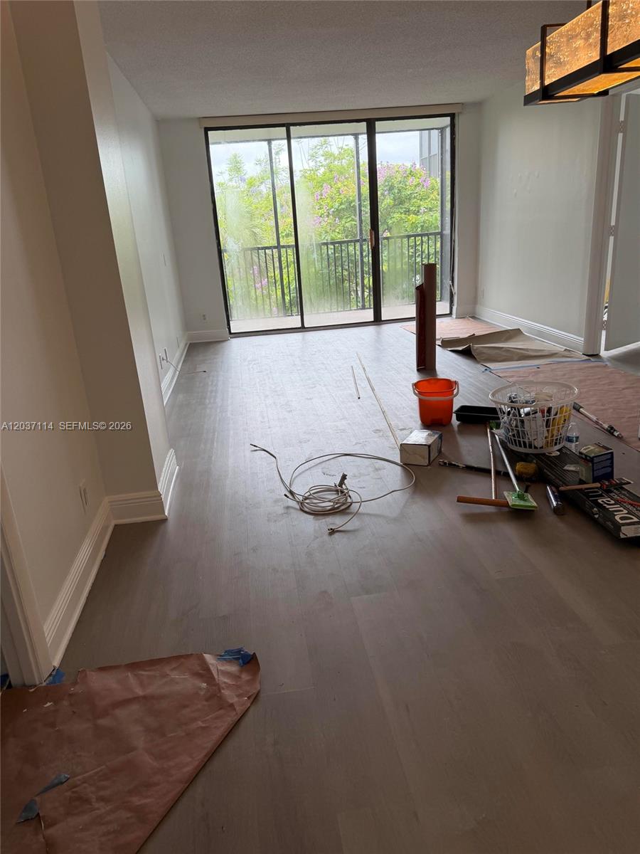 An interior room under renovation features light wood-look flooring and a sliding glass door — AVENTURA, FL