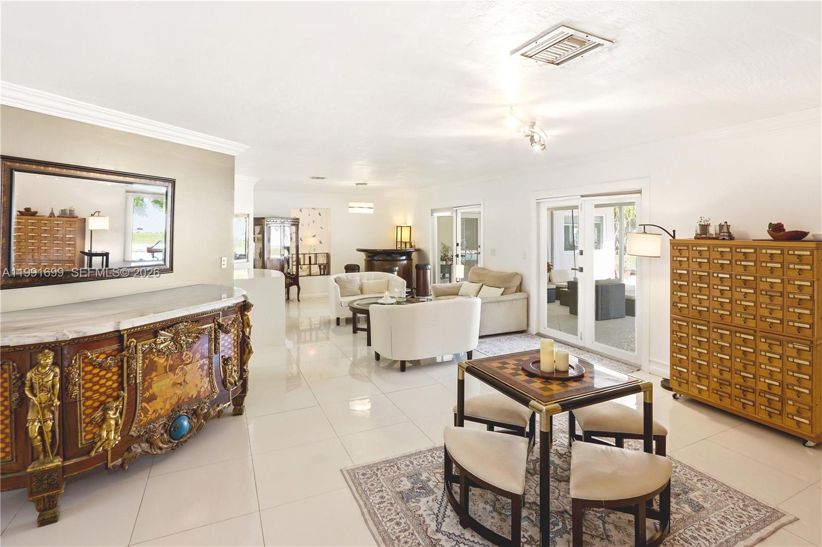 A spacious living room features white tile floors, a game table, and ornate furniture — 9955 SW 74th St, Miami FL 33173, MIAMI, FL