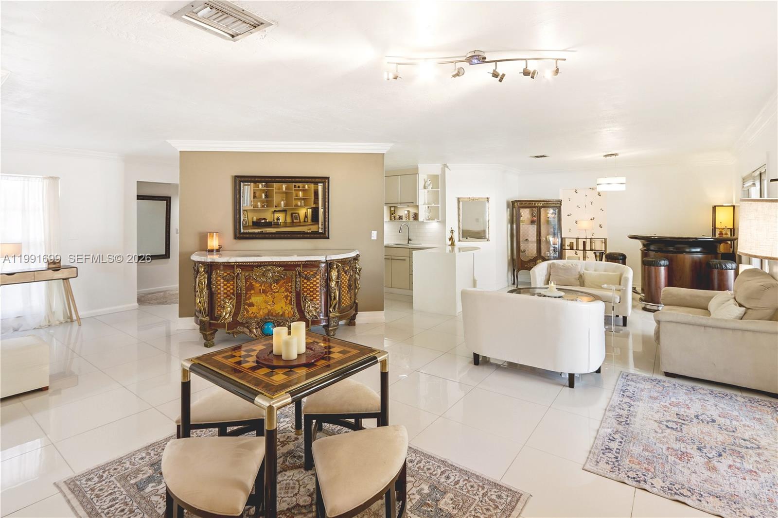 A spacious living area features white tile floors, a decorative sideboard, and a small dining set — 9955 SW 74th St, Miami FL 33173, MIAMI, FL