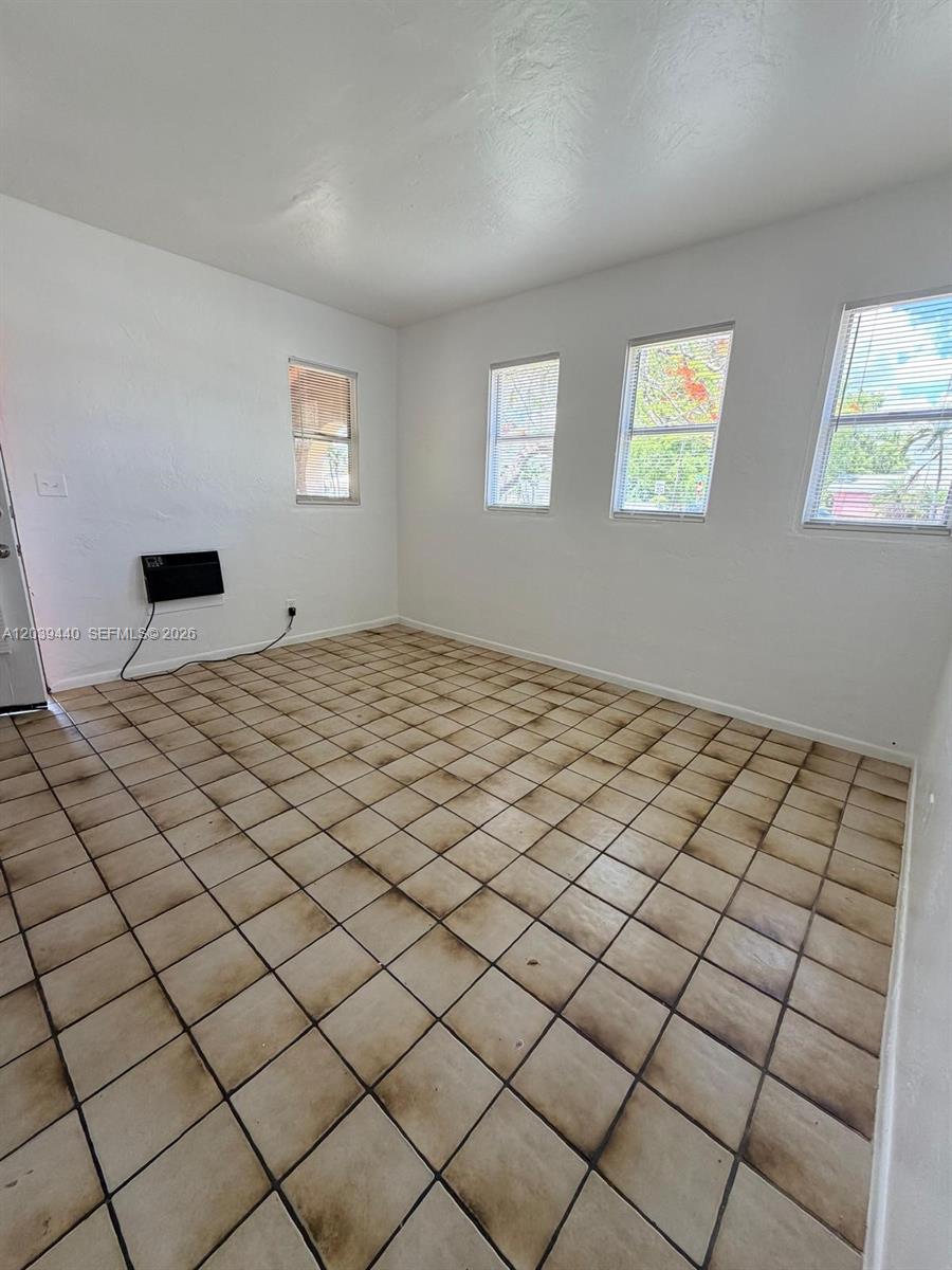 An empty room features white walls, a tiled floor, and three windows — 1844 Taft St # 5, Hollywood FL 33020, HOLLYWOOD, FL