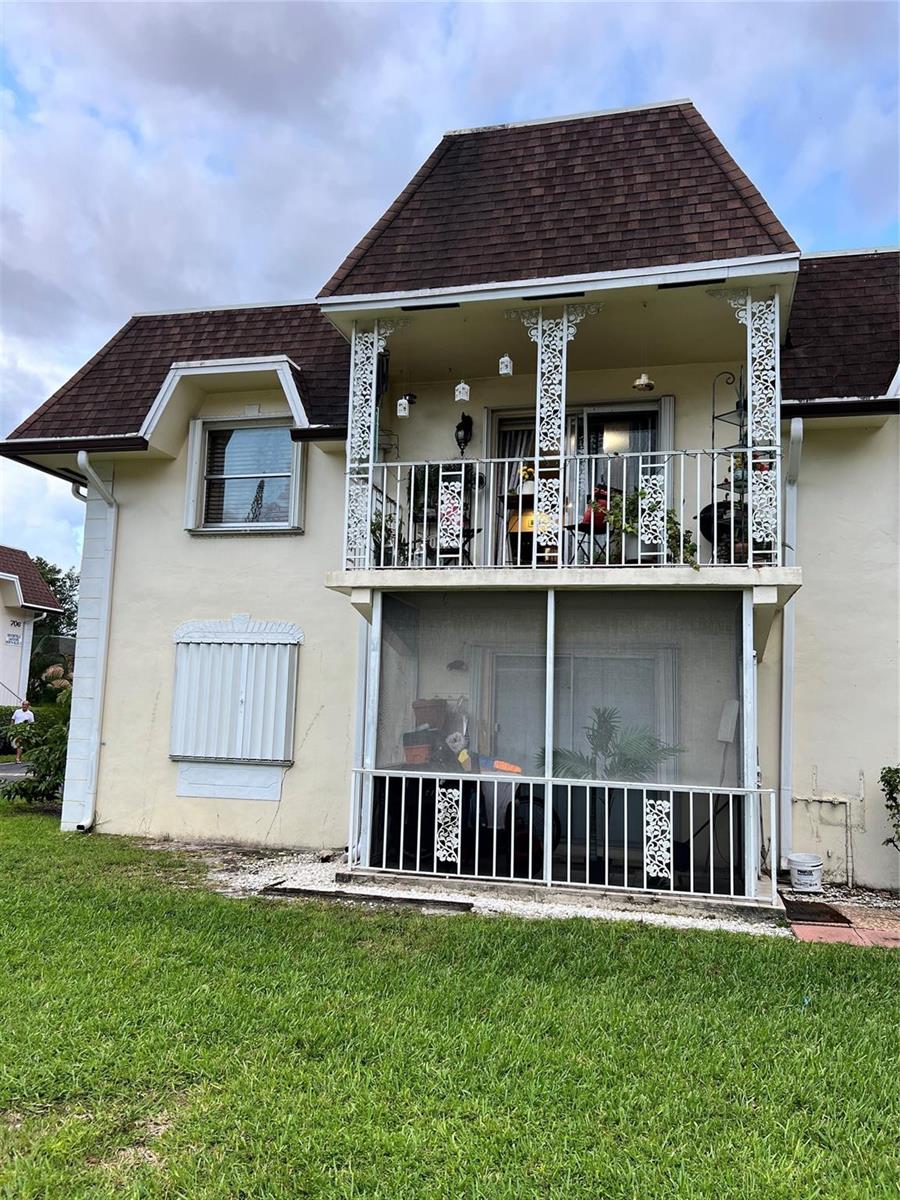 A two-story building exterior features a screened-in ground floor patio and an upper-level balcony — 708 SE 2nd Avenue # 428, Deerfield Beach FL 33441, DEERFIELD BEACH, FL