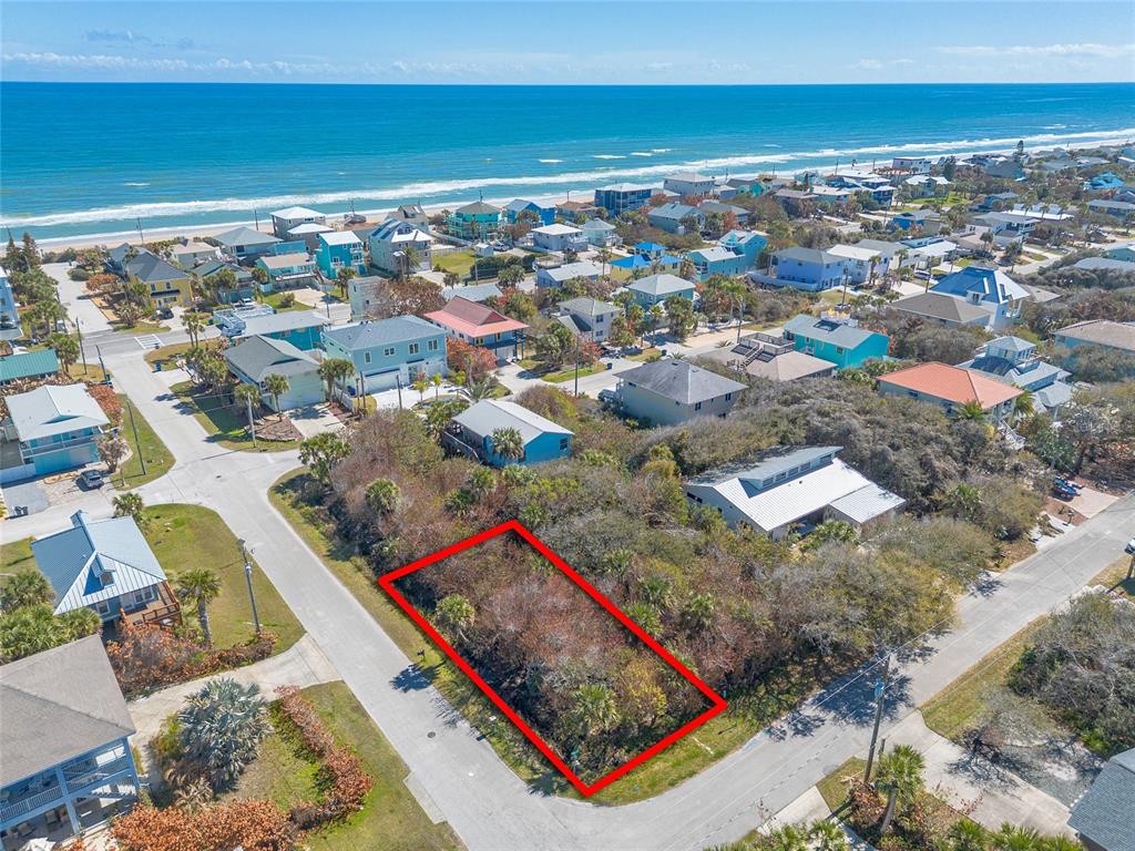 An aerial view shows a vacant, rectangular lot outlined in red within a coastal neighborhood — RIVER ROAD, NEW SMYRNA BEACH, FL