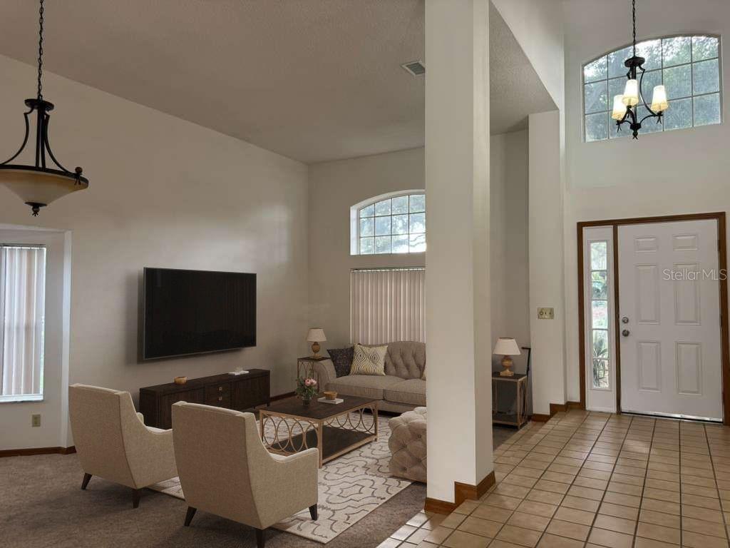 A living room with high ceilings, tile flooring in the entryway, and carpeted seating area — 1206 CORNERSTONE COURT, ORLANDO, FL