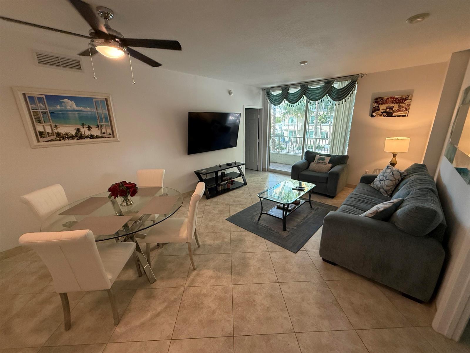 A living and dining area features tile flooring, a glass table, and a blue sofa — 700 E Boynton Beach Boulevard # 203, Boynton Beach FL 33435, BOYNTON BEACH, FL