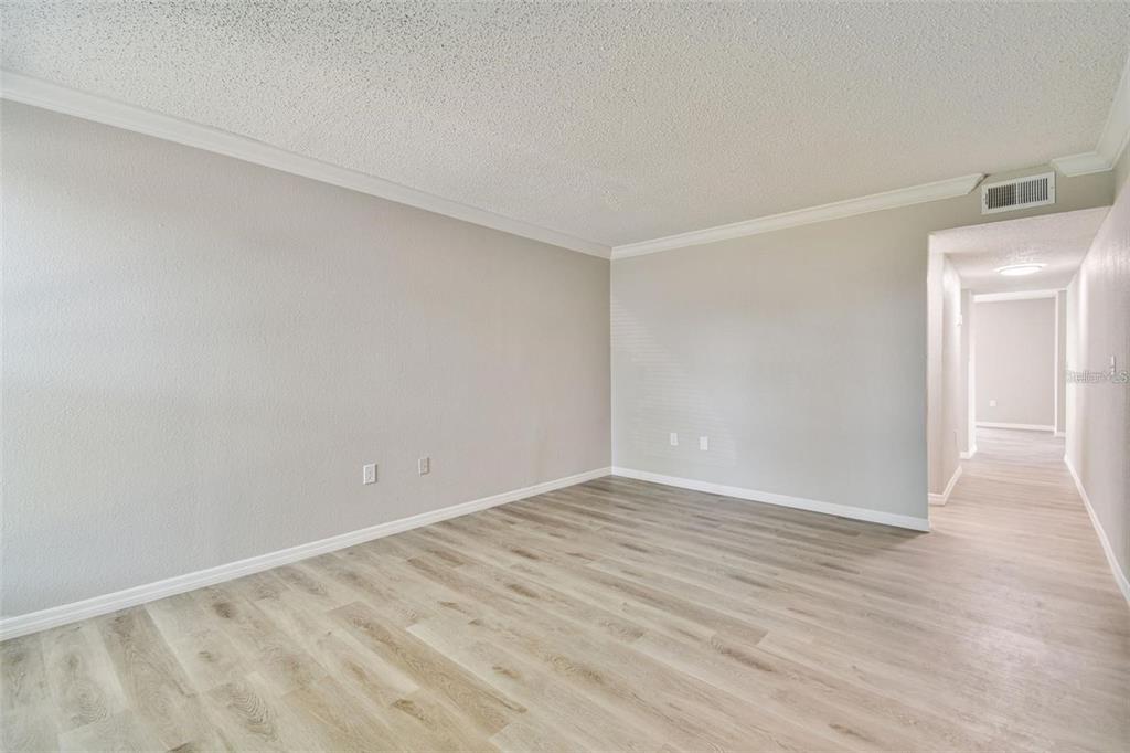 An empty room with light gray walls, white trim, and wood-look flooring — 726 HAVEN PLACE UNIT 726, TARPON SPRINGS, FL