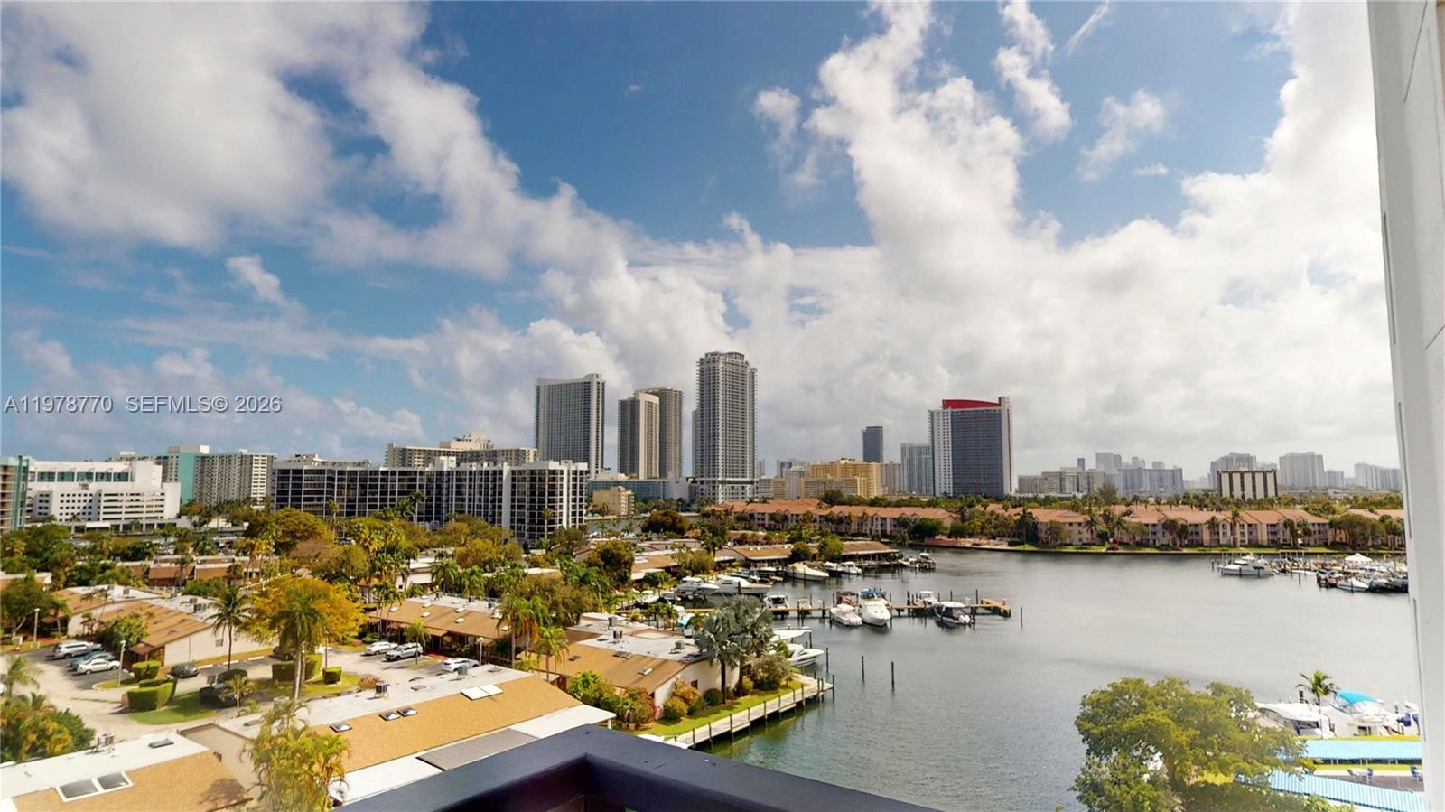 An elevated view of a marina, residential buildings, and a city skyline under a cloudy sky — 2500 PARKVIEW DR # 902, Hallandale Beach FL 33009, HALLANDALE BEACH, FL