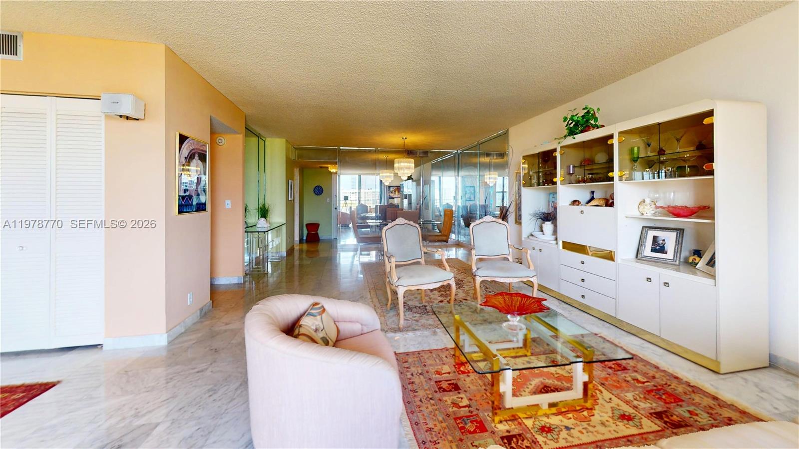 A living room features marble floors, a glass coffee table, two armchairs, and a wall unit — 2500 PARKVIEW DR # 902, Hallandale Beach FL 33009, HALLANDALE BEACH, FL