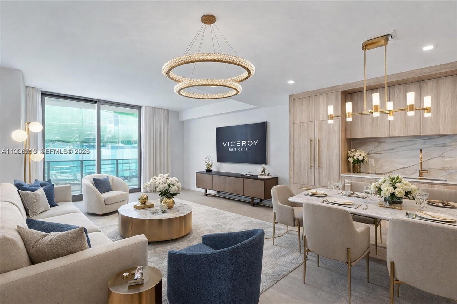 A modern open-concept living and dining area features light wood cabinetry and gold accents — 77 SE 5th Street # 4206, Miami FL 33131, MIAMI, FL