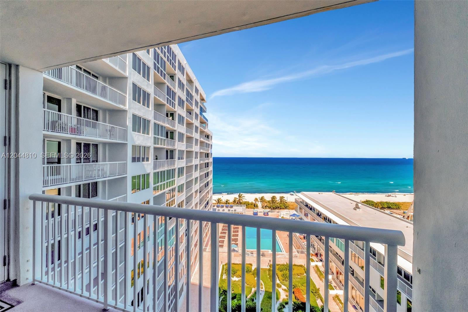 A balcony view overlooks a swimming pool, a beach, and the ocean from a high-rise building — 5401 Collins Ave # 928, Miami Beach FL 33140, MIAMI BEACH, FL
