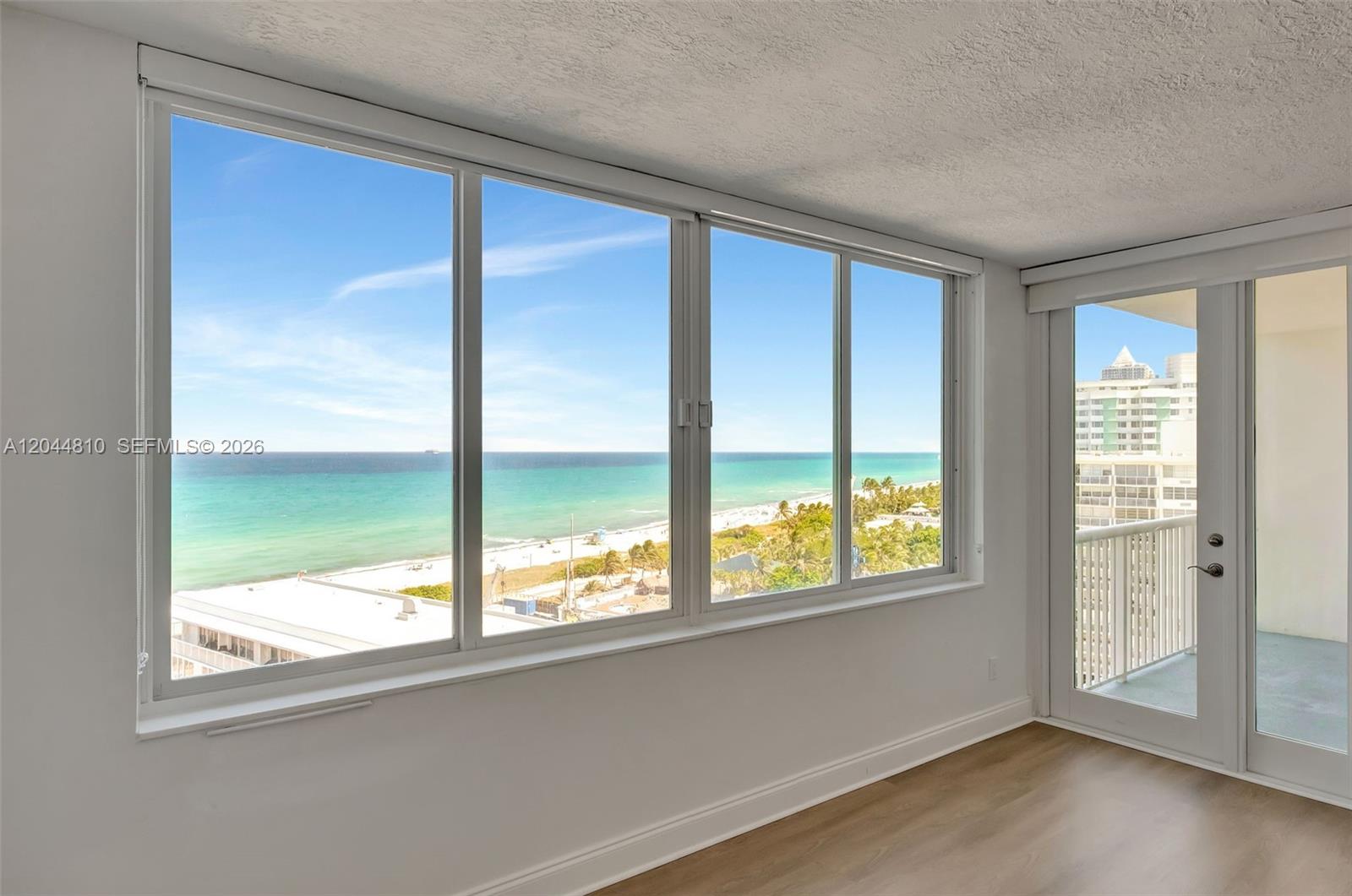 An empty room features large windows with an ocean view and a glass balcony door — 5401 Collins Ave # 928, Miami Beach FL 33140, MIAMI BEACH, FL