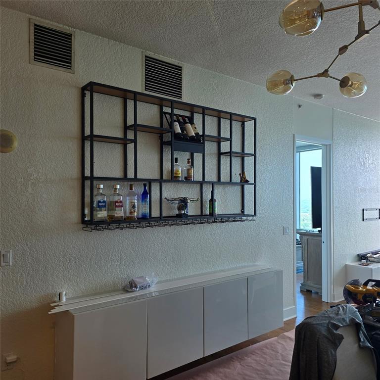 A wall-mounted black metal shelving unit with wine glass racks hangs above a white cabinet — 150 E ROBINSON STREET UNIT 2409, ORLANDO, FL