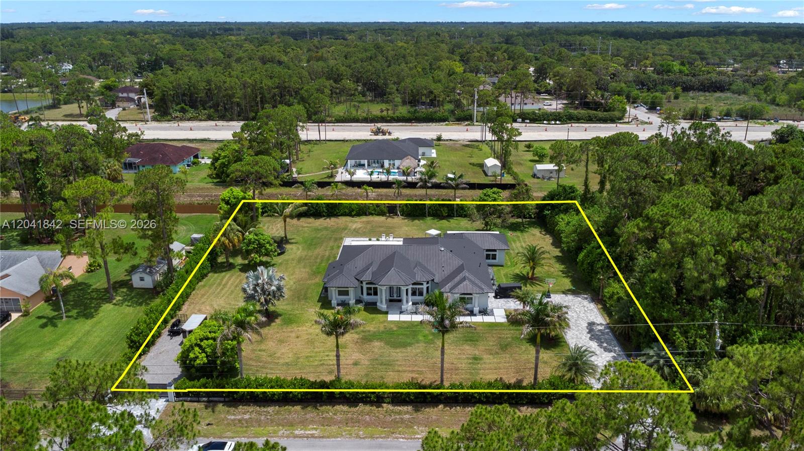 An aerial view shows a single-story house with a dark roof on a large lot — 15436 N 92nd Ct N, Palm Beach FL 33412, PALM BEACH, FL