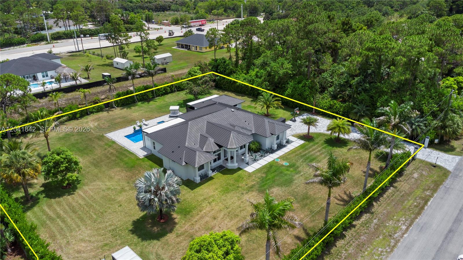 An aerial view shows a house with a dark metal roof, pool, and palm trees — 15436 N 92nd Ct N, Palm Beach FL 33412, PALM BEACH, FL