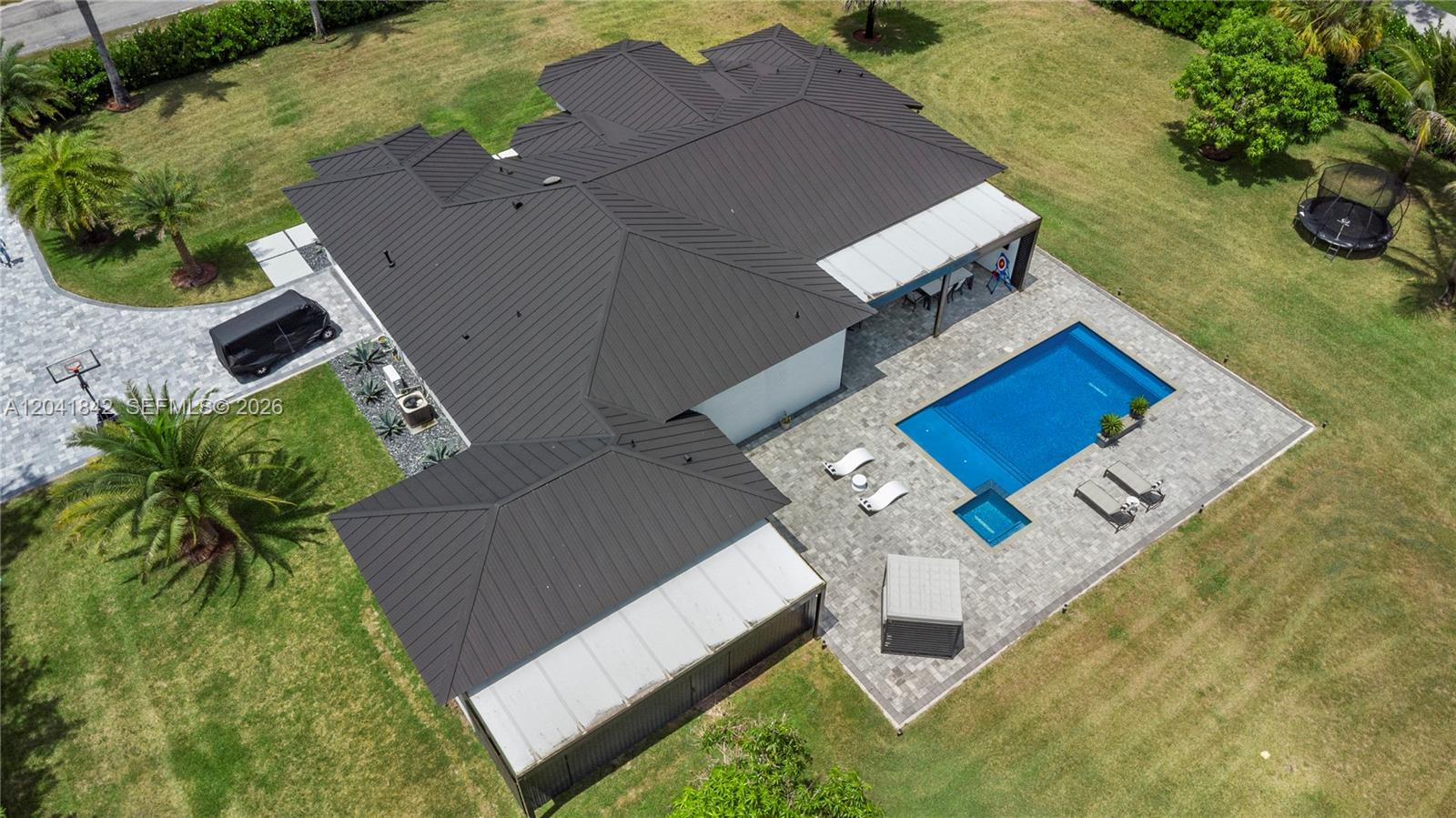An aerial view shows a house with a dark metal roof, pool, and patio — 15436 N 92nd Ct N, Palm Beach FL 33412, PALM BEACH, FL