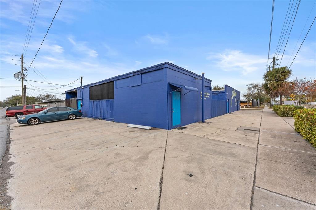 A blue commercial building with a concrete parking lot and a sidewalk on the right — 701 49TH STREET S, GULFPORT, FL