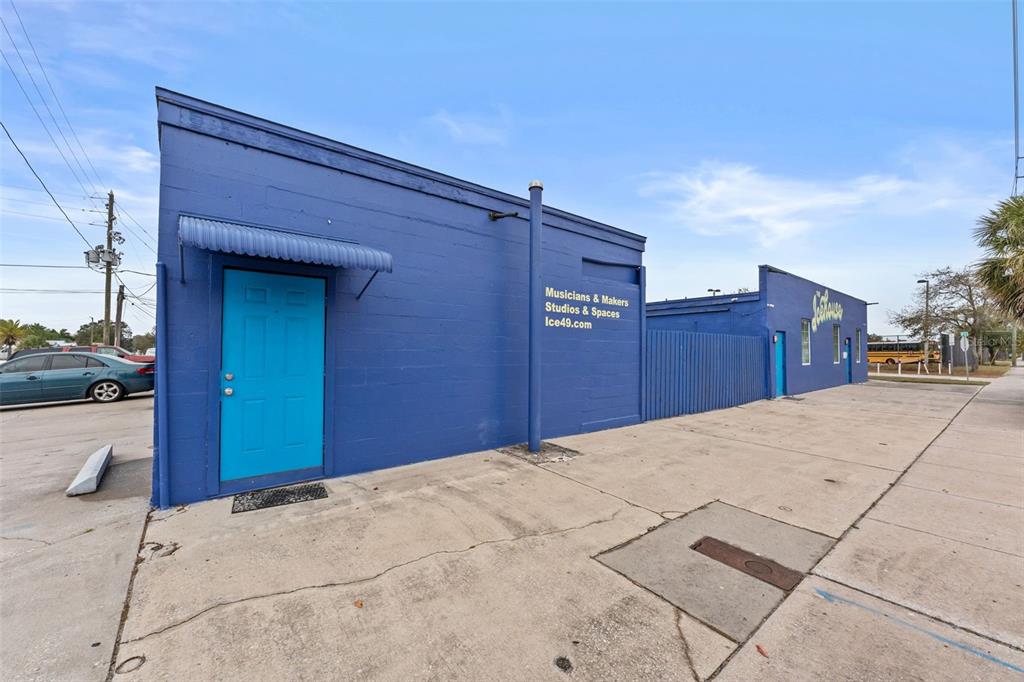 A blue exterior wall of a commercial building features a bright blue door and signage — 701 49TH STREET S, GULFPORT, FL