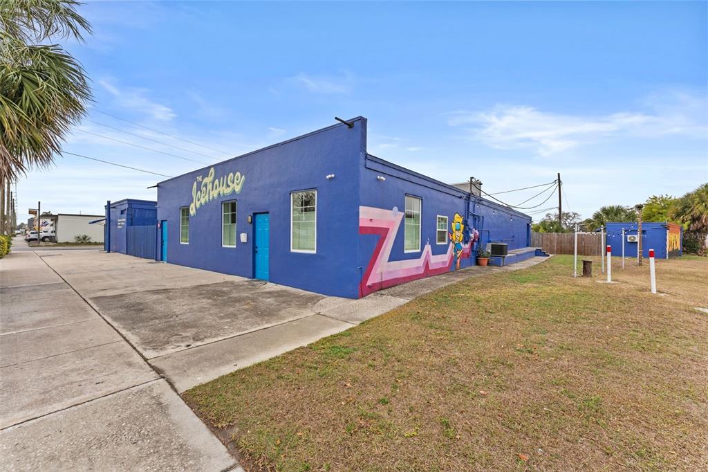 A blue commercial building with a mural and a paved parking area on a sunny day — 701 49TH STREET S, GULFPORT, FL