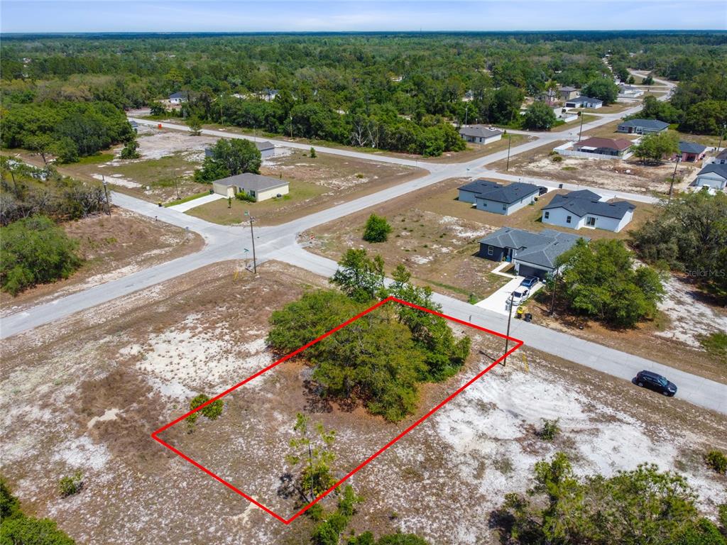 An aerial view shows a vacant rectangular lot outlined in red within a residential neighborhood — 1344 HILLSBOROUGH COURT, KISSIMMEE, FL