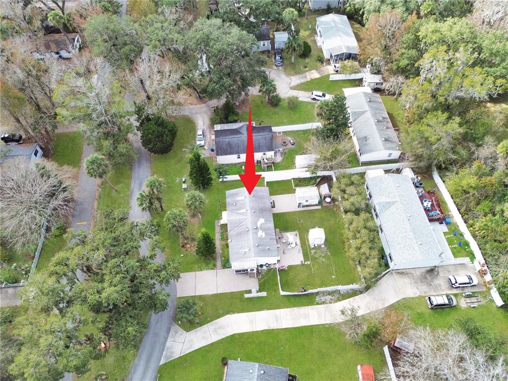 An aerial view shows a residential property with a house, driveway, and surrounding yard — 2031 PORTO BOULEVARD, NEW SMYRNA BEACH, FL