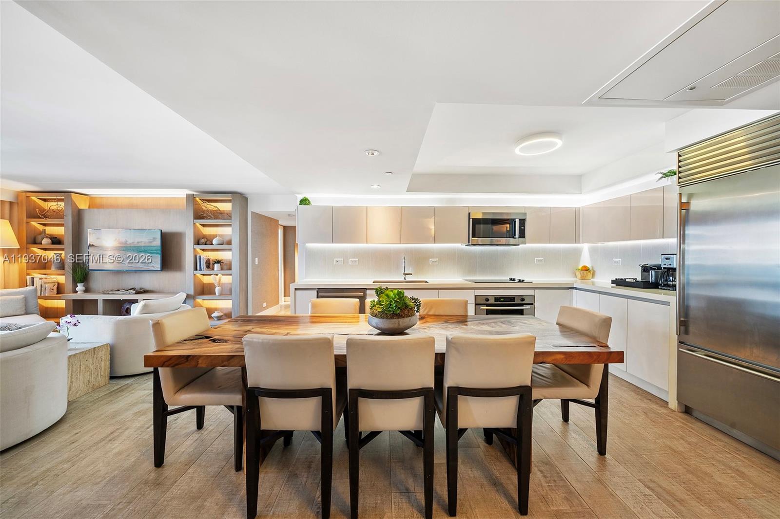 A modern kitchen and dining area feature a live-edge wood table and stainless appliances — 102 24th St # 1207, Miami Beach FL 33139, MIAMI BEACH, FL
