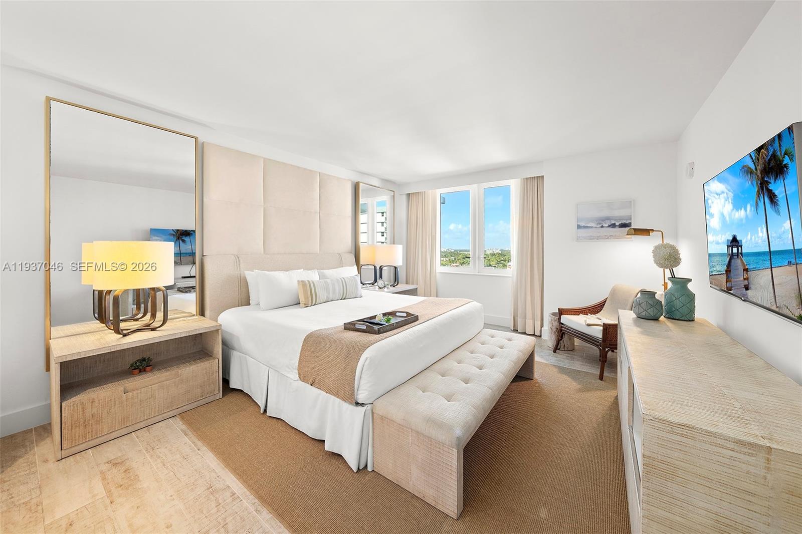 A bedroom features a king bed, upholstered headboard, large mirror, and a wall-mounted television — 102 24th St # 1207, Miami Beach FL 33139, MIAMI BEACH, FL